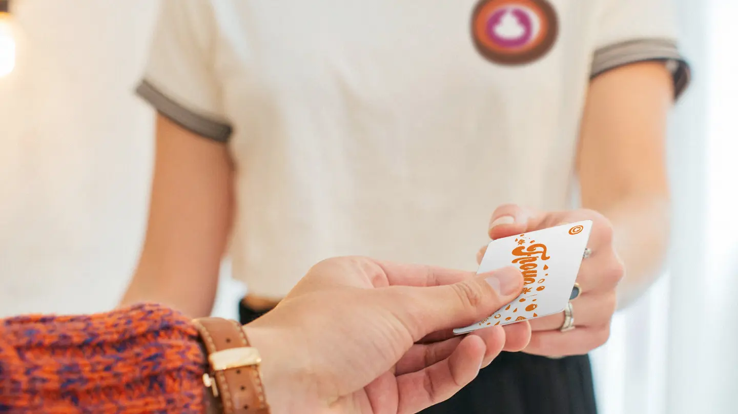 Person handing another person an e-gift gift card
